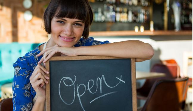 woman standing in front of open sign