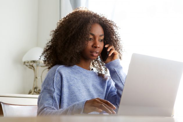 woman talking on the phone while on the computer