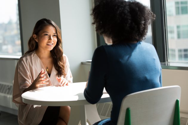 two women talking at an office desk